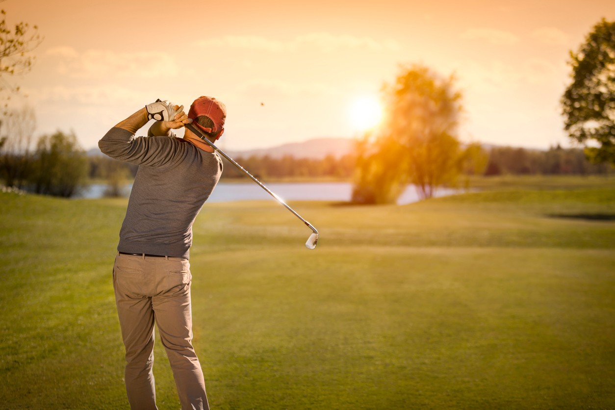 golfer-swinging-club-at-sunset